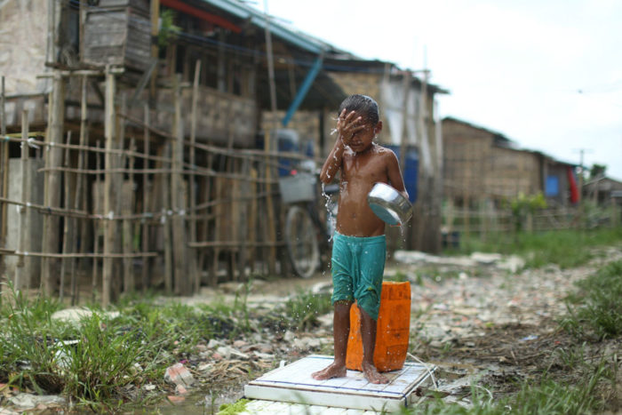 [사진: Hkun Lat / Myanmar Now, 불법거주민 지역에서 세수를 하고 있는 어린이]