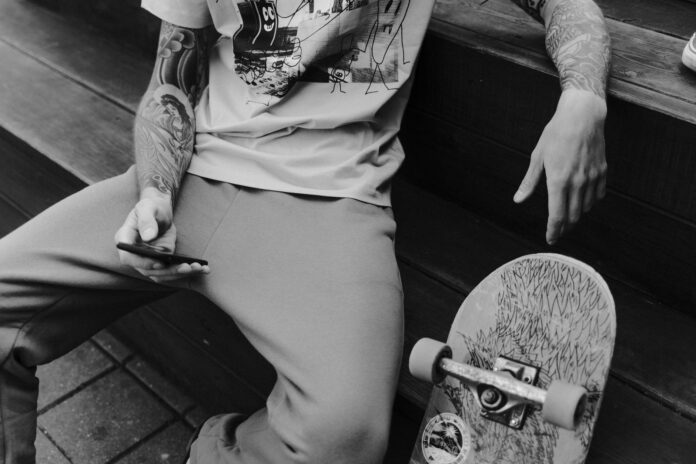 pexels-photo-5560372 grayscale photo of man sitting on a bench holding a smartphone