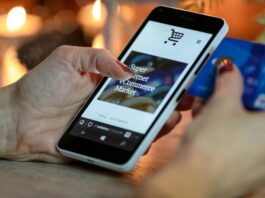 person using black and white smartphone and holding blue card