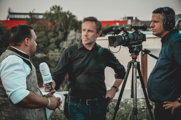 pexels-photo-2872418 man holding microphone while talking to another man